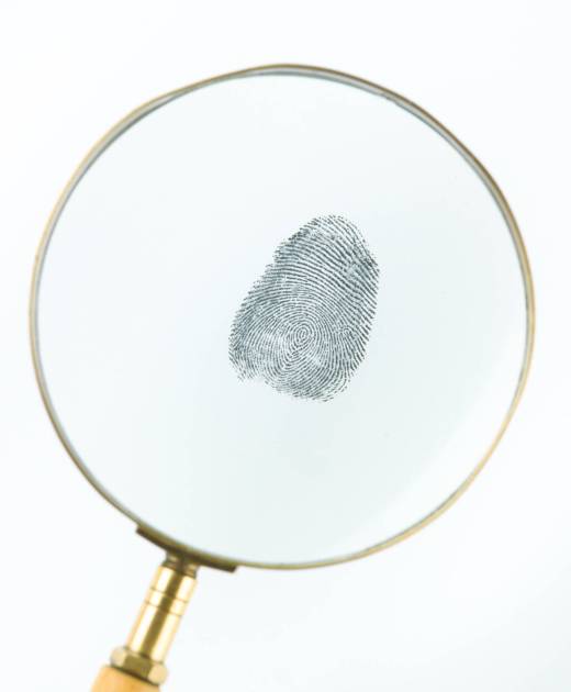 top view of a fingerprint viewed through a magnifying glass, against a white background